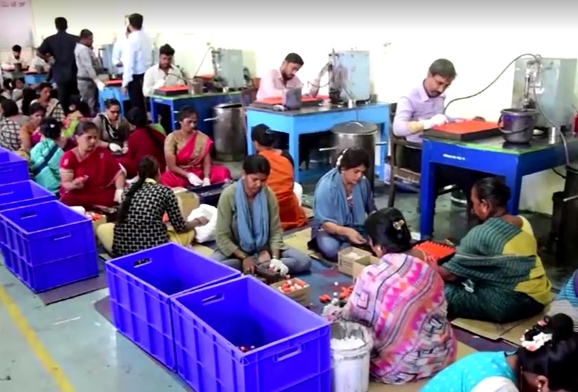 Workers packing orange-coloured plastic ink vials, Mysore, Karnataka, India. - Screengrab/REUTERS