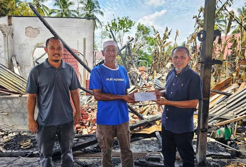 Razak (kanan) menyerahkan sumbangan kepada Mohd Isa (tengah) pada Rabu. - Foto Sinar Harian