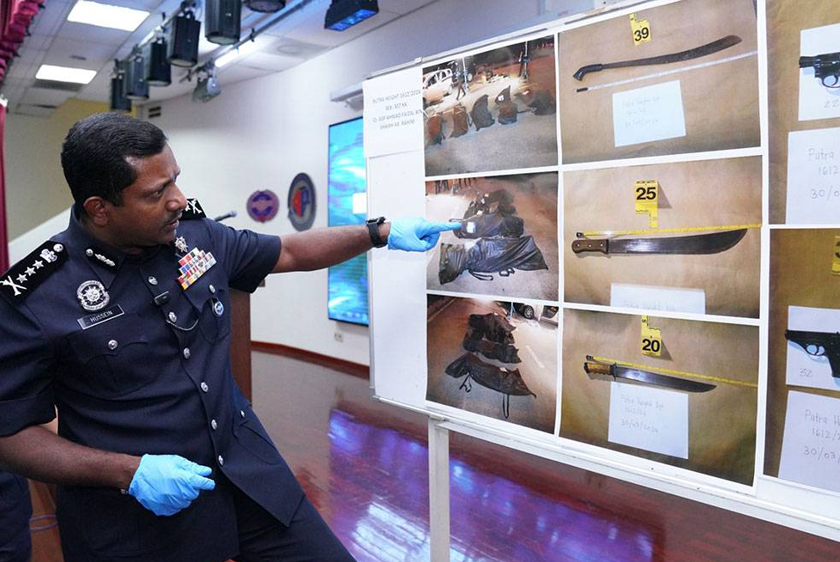 Hussein (kiri) menunjukkan antara senjata dan peralatan yang digunakan suspek yang ditembak mati di Persiaran Harmoni, Putra Heights pada awal pagi Sabtu. - Foto Sinar Harian
