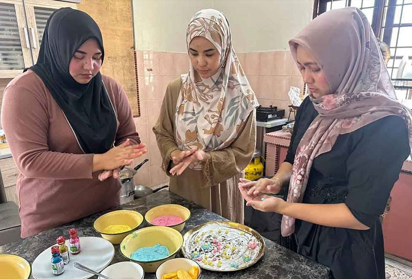 Proses membentuk Bua Loy menjadi bunga dilakukan Nur Nadira (tengah) bersama dua pekerjanya.