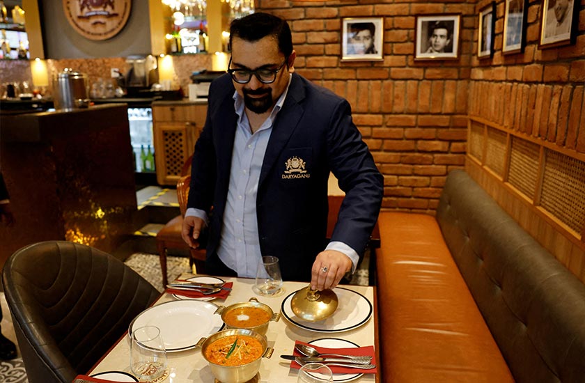 Amit Bagga, CEO of Daryaganj restaurant, shows a freshly prepared butter chicken dish and the lentil dish Dal Makhani inside Daryaganj restaurant at a mall, in Noida, India. - REUTERS