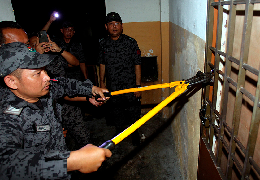 Anggota Imigresen Perak memotong mangga kunci dalam Op Bersepadu di Rumah Pangsa Panorama Lapangan Perdana, awal pagi tadi. --fotoBERNAMA