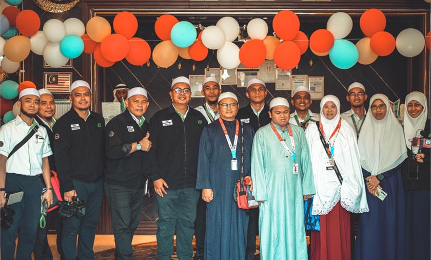 Muhammad Qayyim bersama ibu dan bapanya bergambar kenangan dengan petugas media haji di Mekah.