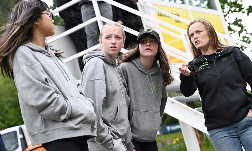 Participants from the More Than Equal Global Driver Development program stand with one of the coaches next to the training racetrack in Saalfelden, Austria. - REUTERS