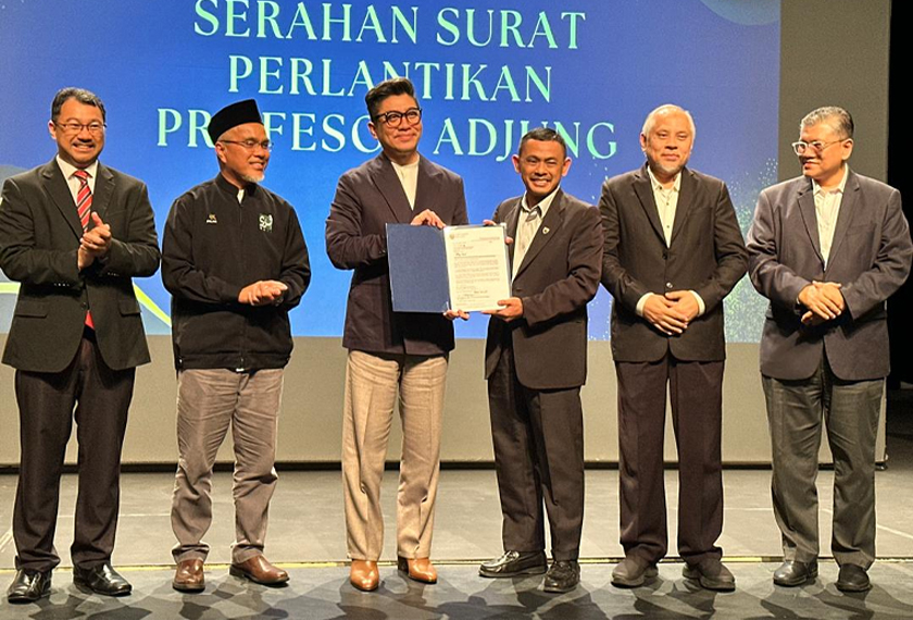 Rizalman (tiga dari kiri) menerima surat pelantikan Prof Adjung daripada Timbalan Naib Canselor Universiti Malaya (Penyelidikan dan Inovasi), Prof Kaharudin Dimyati.