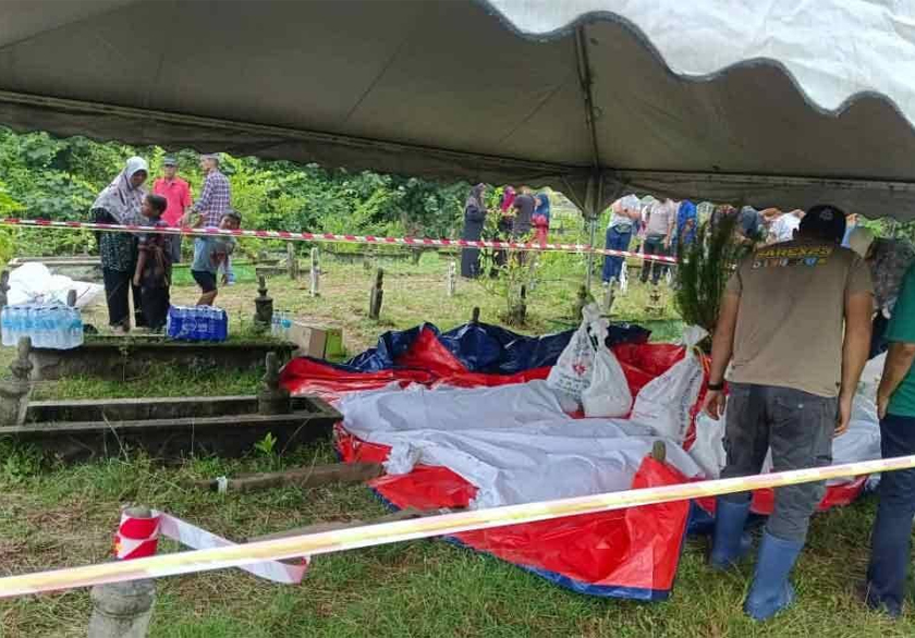 Penduduk kampung bergotong-royong mengalihkan jenazah selepas tanah perkuburan runtuh dalam kejadian hakisan di Kampung Pengkalan Maras, Kuala Nerus.