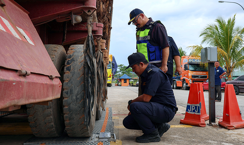 Mohd Misuari (berdiri) memerhatikan jumlah timbangan muatan balak dibawa sebuah lori yang diarah timbang dalam Ops Timber, di Stesen Penguatkuasa Mentara, Gua Musang, 9 Okt 2024. --fotoBERNAMA