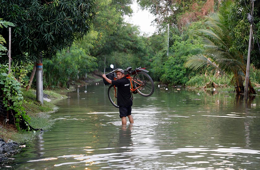 Seorang penduduk Kampung Nelayan Bagan Hailam meredah air apabila laluan rumahnya mula dinaiki air berikutan fenomena air laut pasang besar. - Foto Bernama