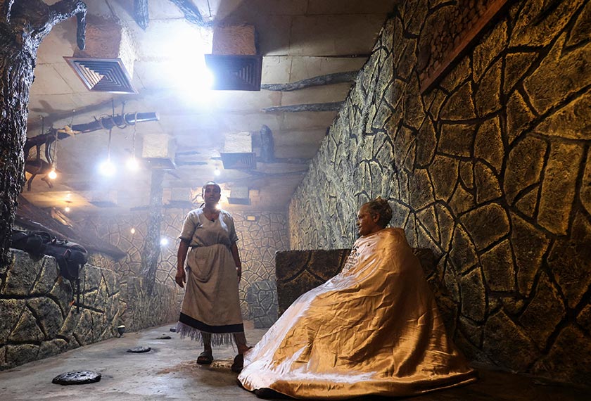A masseuse applies a smoke, made from traditional beauty remedies, on her customer at the Fana 