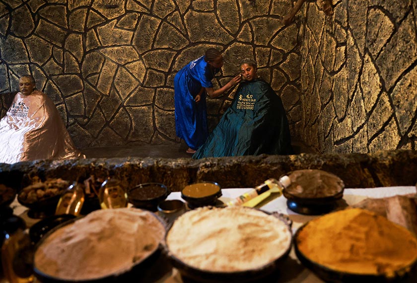 A masseuse applies a scrub made from traditional remedies on her customer Saba Yilma, at the Fana 