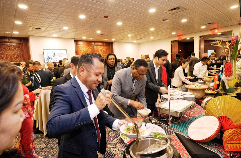 Tetamu-tetamu pada majlis sambutan Hari Kebangsaan menikmati juadah Malaysia.