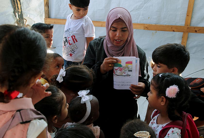 Palestinian teacher Israa Abu Mustafa gives a class to students inside a tent set up on the rubble of her house as war disrupts a new school year, in Khan Younis, in the southern Gaza Strip, September 4, 2024.  - REUTERS 