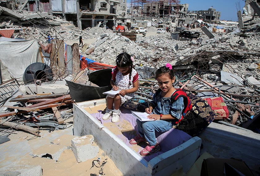 Palestinian students sit on the rubble after attending a class in a tent set up on the ruins of the house of teacher Israa Abu Mustafa, as war disrupts a new school year, in Khan Younis, in the southern Gaza Strip, September 4, 2024. - REUTERS