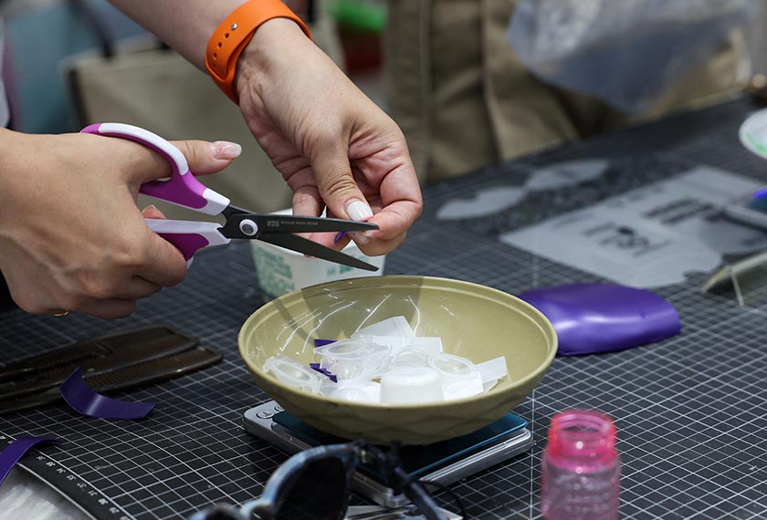 A person cuts up plastic waste to be used as part of her sunglasses at Trash Kitchen in Taipei, Taiwan. - REUTERS