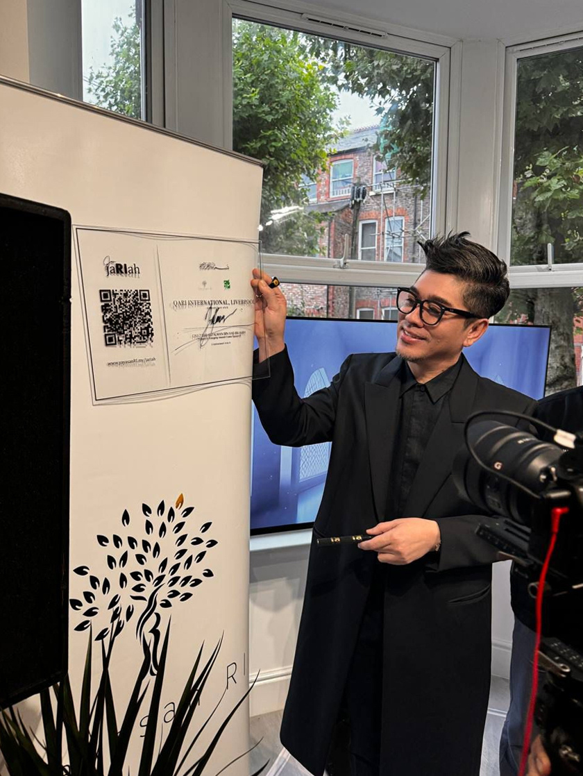 Rizalman menandatangani plak sebagai simbol perasmian Rumah Komuniti Malaysia di Livepool pada Ahad lepas.