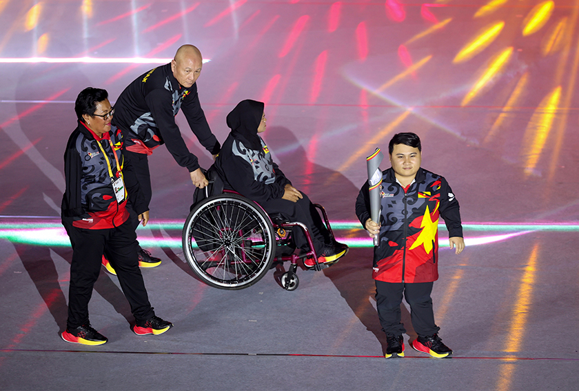 Bonnie (kanan) membawa obor untuk dinyalakan pada Majlis Perasmian Temasya Para SUKMA Sarawak 2024 di Stadium Perpaduan Petra Jaya malam tadi. -- fotoBERNAMA 