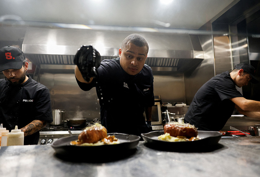 Spain's viral chef Elias Dosunmu with over 20 million followers across all of his social media puts salt on dishes in his restaurant in Madrid, Spain. - REUTERS