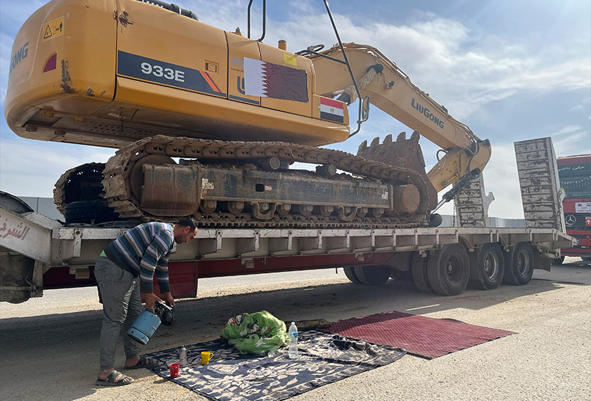 Seorang pemandu trak yang membawa jentolak berehat sambil menunggu untuk memasuki Gaza di sempadan Rafah, Mesir, 18 Feb 2025. (Foto AP)