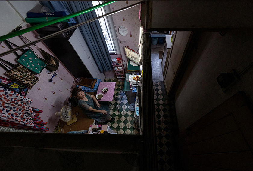 Xiao Bo, 60, poses for a photo at her subdivided flat in Hong Kong, China. - REUTERS