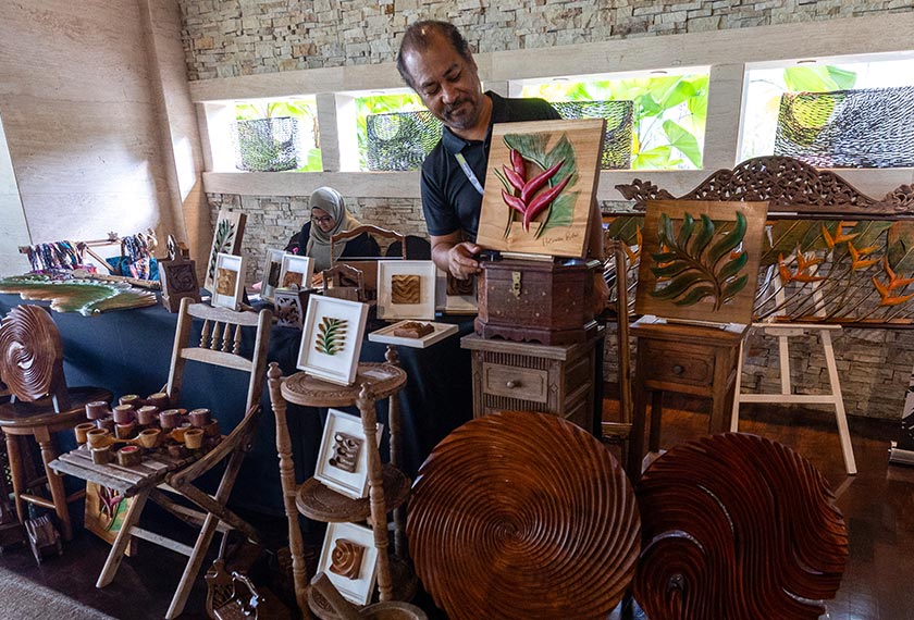 Pegawai Pemasaran Kraftangan Berasaskan Kayu, Azrizal Abd Aziz, bersama dengan barang seni dan cenderamata yang dihasilkan melalui teknik ukiran oleh artis tempatan, di reruai kraftangan yang dibuka sempena Permukiman Menteri-Menteri Luar ASEAN (AMM). - Foto BERNAMA