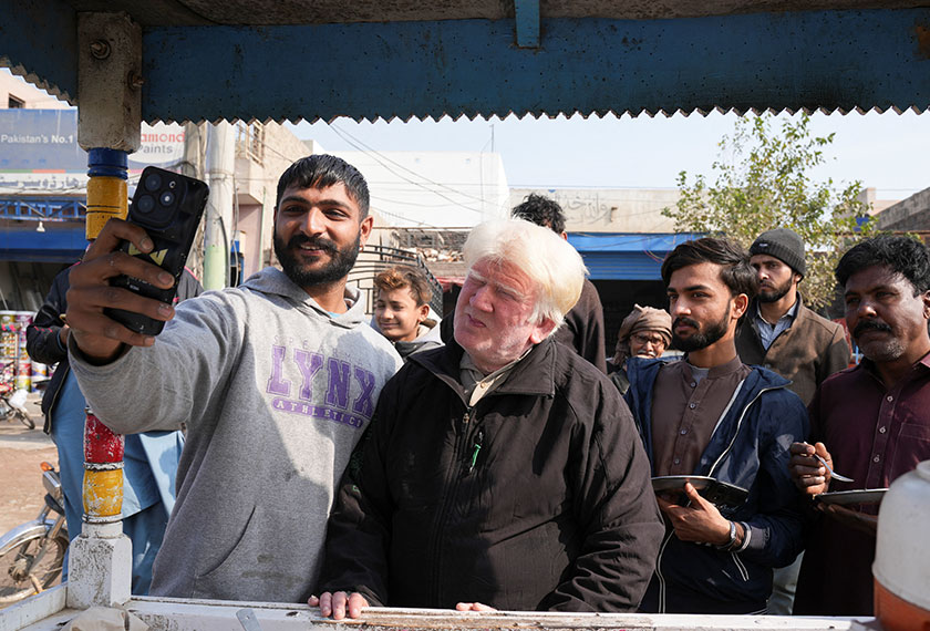 Saleem Bagga, seen by some as a lookalike of U.S. President-elect Donald Trump, poses for a selfie with a customer while selling kheer, a traditional South Asian rice pudding, along a road in Sahiwal, Pakistan. - REUTERS