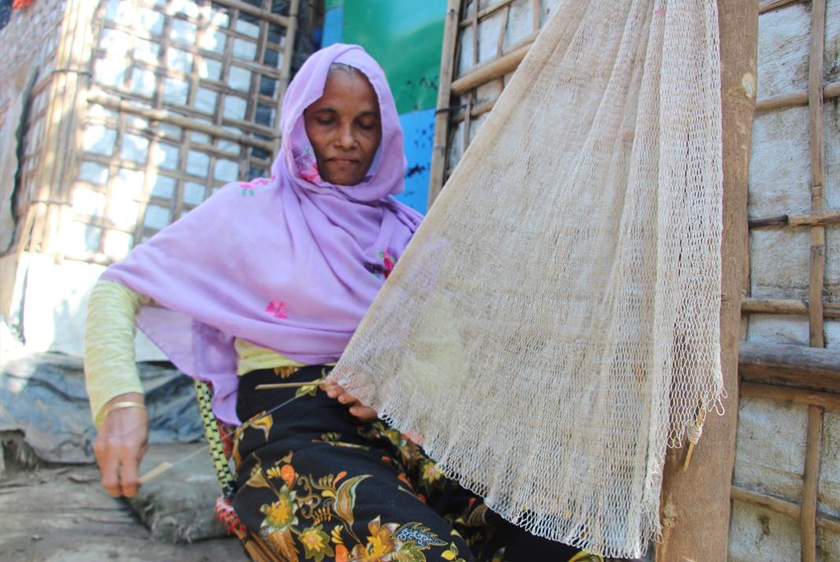 Sokina menganyam jaring ikan; kemahiran yang dipelajarinya baru-baru ini. - Gambar  BDRCS/ IFRC