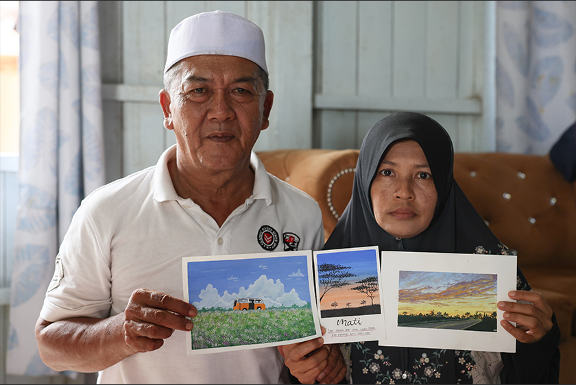 Rosde Yaakub,58, dan Juariah Abd Rahman, 48, menunjukkan tiga lukisan yang dihasilkan anak mereka Allahyarham Muhammad Mustaqim semasa ditemui di Kampung Telaga Nibung, hari ini. - Foto Bernama