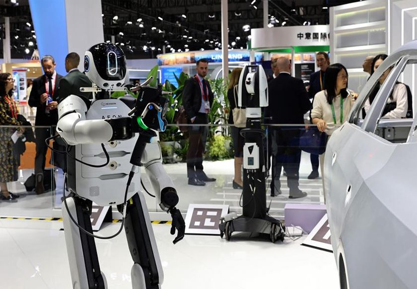 Visitors view Hexagon's industrial humanoid robot AEON demonstrating the three-dimensional scanning, which is the first exhibition of industrial automation application scenarios of AEON in China, during the 8th China International Import Expo (CIIE) in east China's Shanghai, Nov. 5, 2025. - Xinhua/Fang Zhe