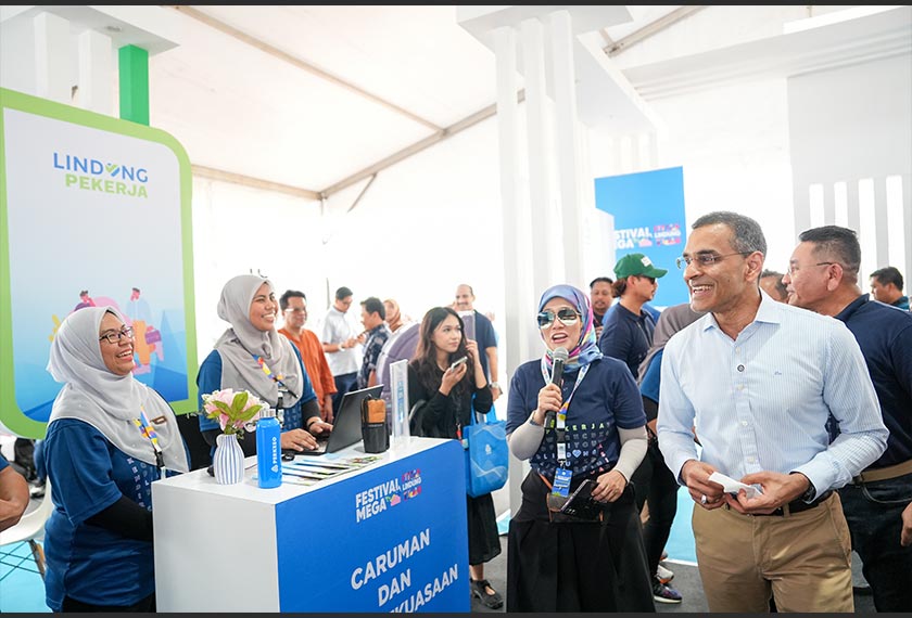 Mohammed Azman beramah mesra bersama petugas di reruai PERKESO sempena Festival Mega i LINDUNG u 2025 yang menghimpunakn pelbagai insiatif perlindungan sosial dan peluang pekerjaan untuk orang ramai. - Foto PERKESO