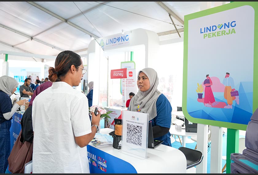 Petugas PERKESO memberi penerangan kepada pengunjung mengenai manfaat program Lindung Pekerja. - Foto PERKESO