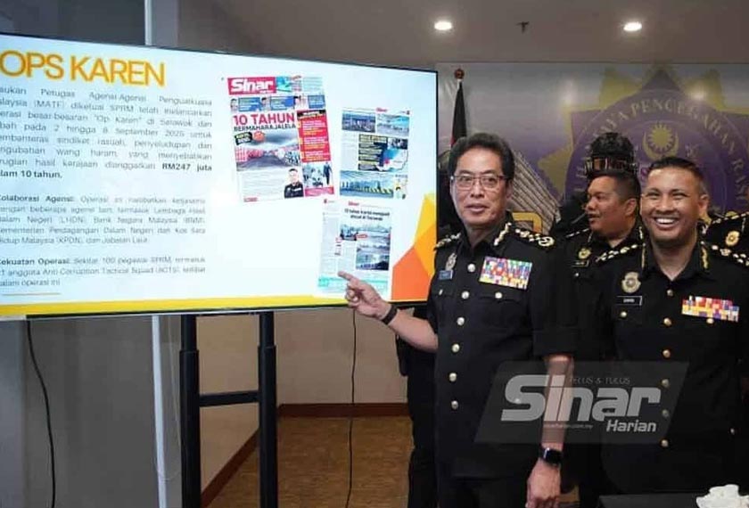 Azam (kiri) menunjukkan paparan laporan akhbar Sinar Harian mengenai Op Karen. - Foto Sinar Harian