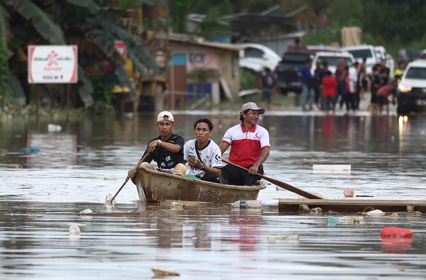 PAITAN, 21 Feb - Beberapa penduduk menggunakan perahu untuk keluar selepas jalan Paitan–Kanibongan terputus akibat dinaiki air banjir di Kampung Kubambangan ketika tinjauan, hari ini.   -- fotoBERNAMA