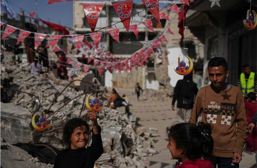 Palestinians hang decorations beside the rubble of destroyed homes as they prepare for the holy month of Ramadan in Khan Younis, southern Gaza Strip, Sunday, Feb. 15, 2026. (AP Photo/Abdel Kareem Hana)