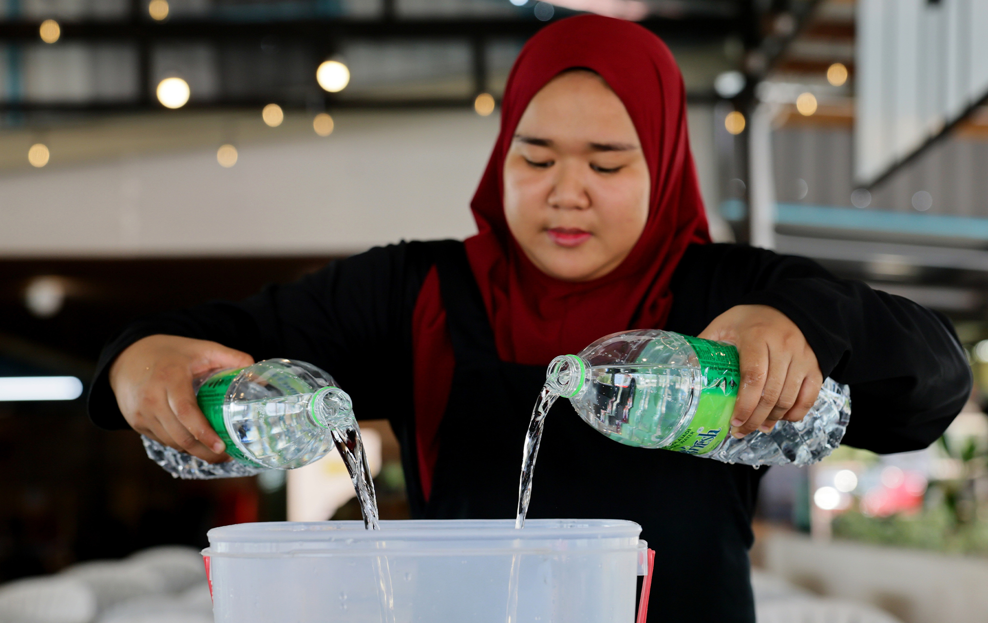 DUNGUN, 11 April -- Pengusaha restoran di Tebing Tembah, Paka, Nurul Miezan Qamaliena Mazidi, 23, mengisi air mineral ke dalam bekas air minuman untuk pelanggan semasa ditemui di Tebing Tembah, Paka.  Mereka terpaksa berbelanja sebanyak RM300 sehari untuk membeli air mineral itu untuk disediakan kepada pelanggan berikutan masalah air payau dan berkarat.  Penduduk di sekitar Paka dekat sini kecewa dengan masalah bekalan air payau, berkarat dan tekanan rendah sehingga menimbulkan kesulitan dalam kehidupan seh