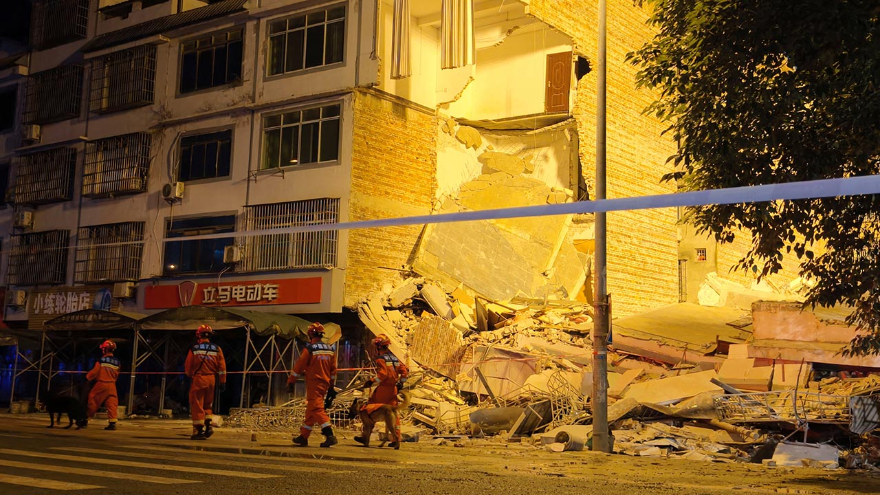 Rescue workers walk past a damaged building following an earthquake at Taiyang village in Liuzhou, Guangxi Zhuang Autonomous Region, China May 18, 2026. cnsphoto via REUTERS 