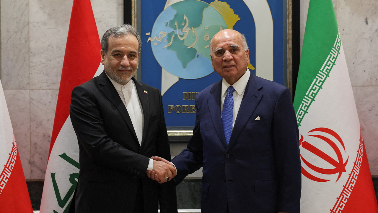 Iraqi Foreign Minister Fuad Hussein shakes hands with Iranian Foreign Minister Abbas Araqchi on the day of a joint press conference, in Baghdad, Iraq, June 28, 2026. REUTERS/Thaier Al-Sudani