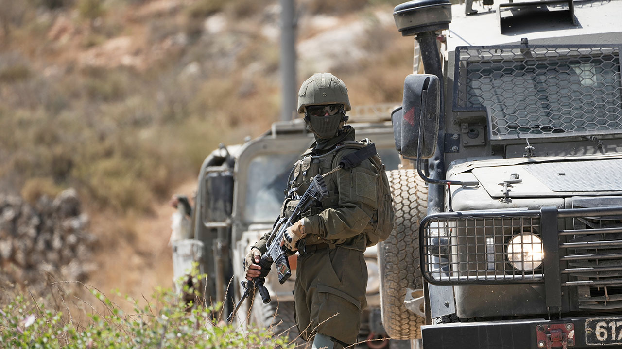 Israeli army units block the road and prevent Palestinian villagers, supported by foreign and Israeli peace activists, from reaching their lands where Israeli settlers established a new outpost, at the West Bank town of Qabalan, southeast of Nablus, Saturday, July 4, 2026. (AP Photo/Majdi Mohammed)
