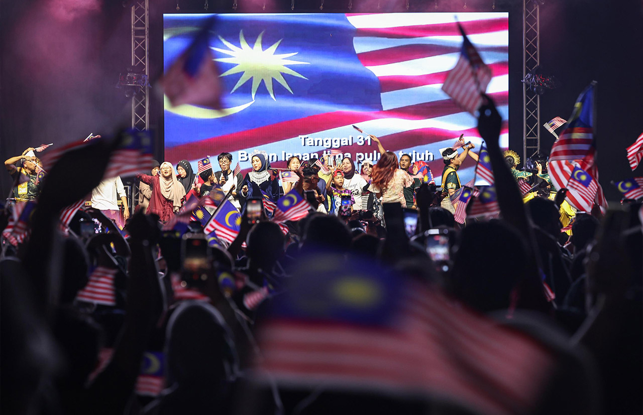 PUTRAJAYA, 31 Ogos - Orang ramai mengibarkan Jalur Gemilang ketika kira detik detik Kemerdekaan pada RIUH Merdeka sempena Ambang Merdeka di Putrajaya malam ini bagi meraikan detik menjelang sambutan Hari Kebangsaan 2026. Pelbagai aktiviti seni, budaya, muzik dan sajian tempatan disediakan bagi menyemarakkan semangat patriotisme. - fotoBERNAMA (2026) HAK CIPTA TERPELIHARA