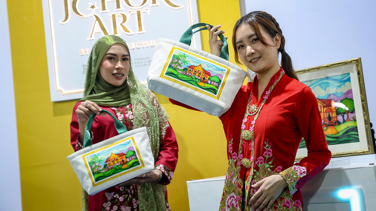 JOHOR BAHRU, 20 Sept - Annabella Chua (kanan) bersama Noor farahin Hashim (kiri) memperagakan koleksi Royal Johor Art By RZS Collection " Beg Rumah Kampung yang dirasmikan oleh Raja Permaisuri Agong Raja Zarith Sofiah di Dataran Bandaraya Johor Bahru di sini hari ini. Karya seni dihasilkan Seri Paduka Baginda bertemakan 'Balik Kampung' itu menonjolkan salah satu aspek utama perayaan Aidilfitri dan semua perayaan di Malaysia, sebagai peringatan kepada orang ramai supaya berbangga dengan warisan dan kebudayaa