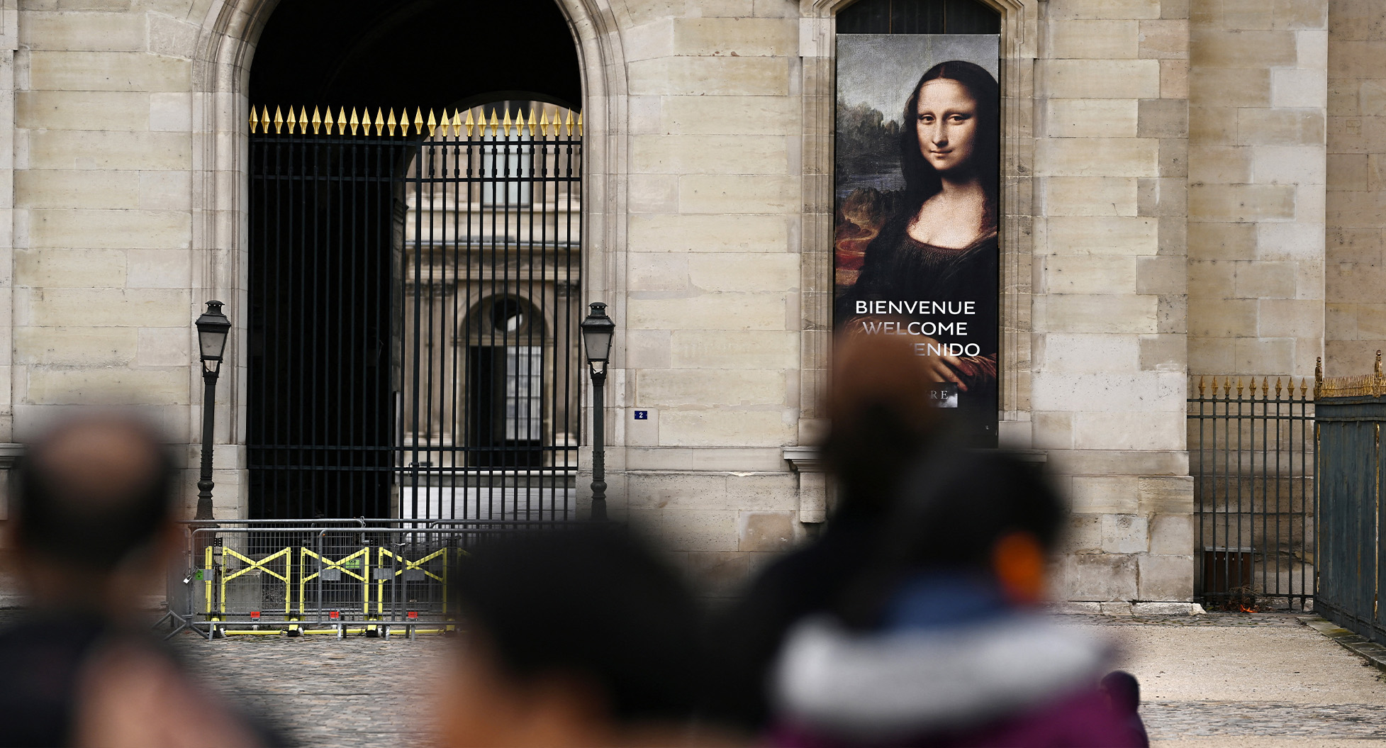 People stand in front of a poster depicting "Mona Lisa" (La Joconde) in front of the Louvre Museum, which is closed all day due to the fears of renewed turmoil in Paris ahead of nationwide protests called by the "Yellow Vests" movement joined by French high school and university students, against the cost of living and rising fuel prices in France, October 24, 2026. REUTERS/Dylan Martinez